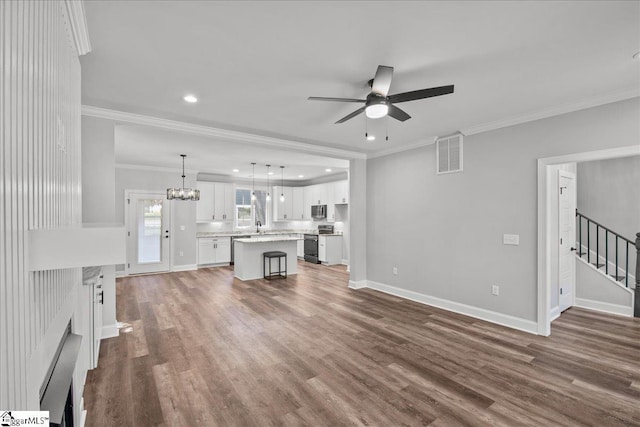 unfurnished living room with dark hardwood / wood-style flooring, sink, ceiling fan with notable chandelier, and ornamental molding