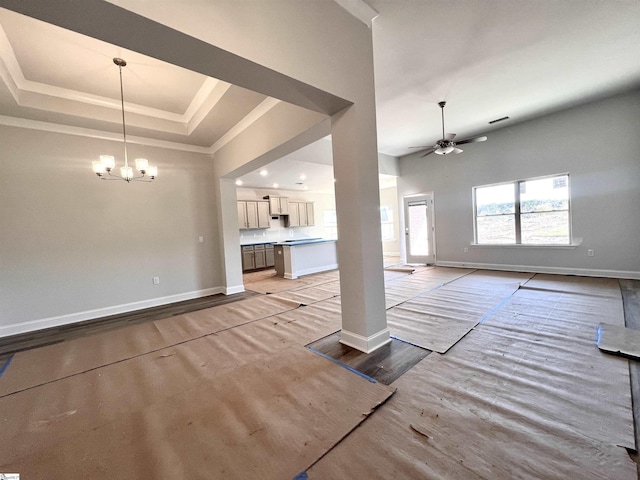 unfurnished living room featuring a raised ceiling, light wood-type flooring, crown molding, and ceiling fan with notable chandelier