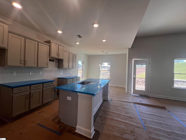 kitchen with pendant lighting, a center island, and gray cabinetry