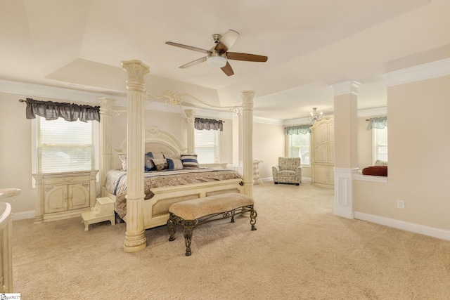 carpeted bedroom featuring a tray ceiling, ornate columns, ceiling fan, and ornamental molding