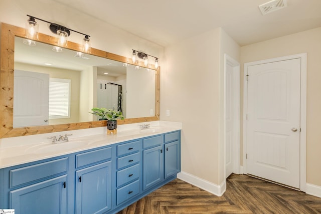 bathroom with parquet flooring, vanity, and a shower with shower door