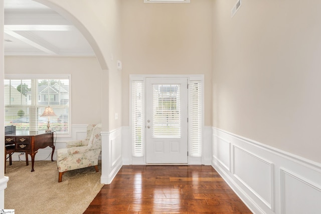 foyer entrance featuring beam ceiling, dark hardwood / wood-style floors, crown molding, and coffered ceiling