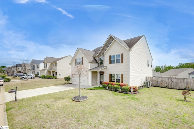 view of front of house with a front lawn, central AC unit, and a garage