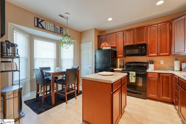 kitchen with black appliances, a center island, light tile patterned floors, and hanging light fixtures