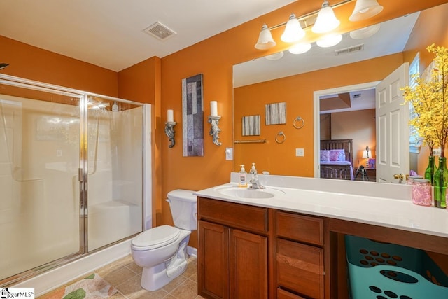 bathroom featuring tile patterned floors, vanity, toilet, and a shower with shower door