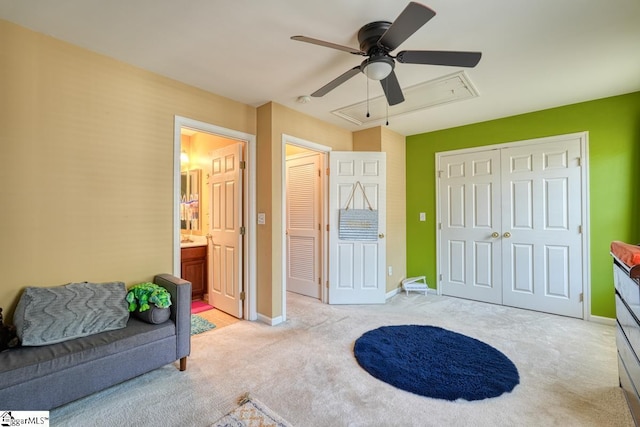 bedroom with ceiling fan, ensuite bathroom, and light colored carpet