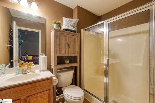 bathroom featuring vanity, toilet, and a shower with shower door