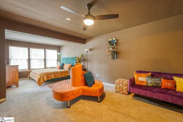 carpeted bedroom featuring beamed ceiling and ceiling fan