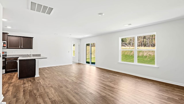 unfurnished living room with dark hardwood / wood-style floors and sink