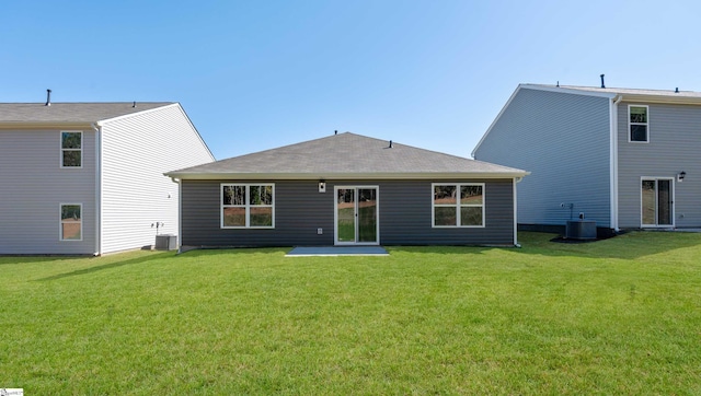 rear view of house with a lawn and central AC unit