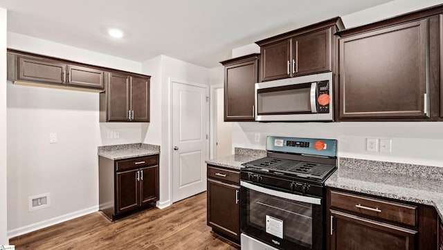 kitchen featuring dark brown cabinetry, stainless steel appliances, light stone counters, and dark hardwood / wood-style floors