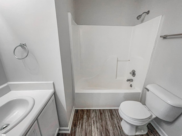 full bathroom featuring hardwood / wood-style floors, vanity, toilet, and bathtub / shower combination