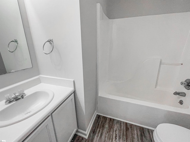 full bathroom featuring hardwood / wood-style floors, vanity, toilet, and tub / shower combination