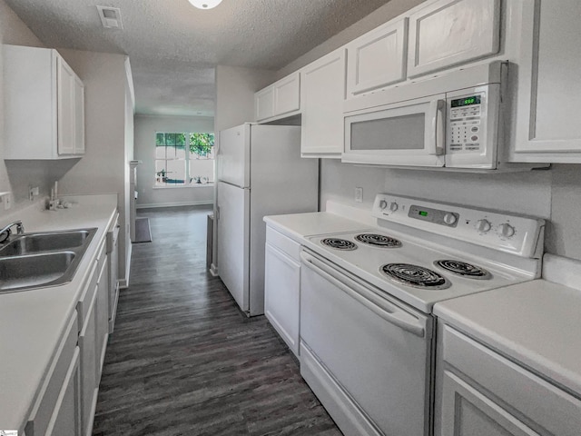 kitchen with dark hardwood / wood-style flooring, a textured ceiling, white appliances, sink, and white cabinetry