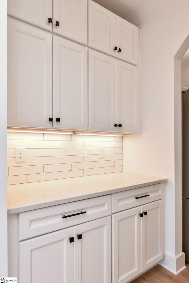 120 Club Cart Rd, Travelers Rest, SC 29690 - kitchen with backsplash, white cabinets, light stone counters, freestanding refrigerator, and light wood-style flooring