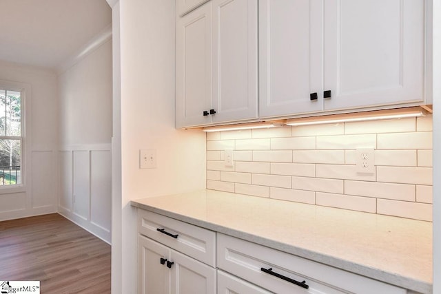 120 Club Cart Rd, Travelers Rest, SC 29690 - kitchen featuring light wood finished floors, decorative backsplash, white cabinetry, a decorative wall, and wainscoting