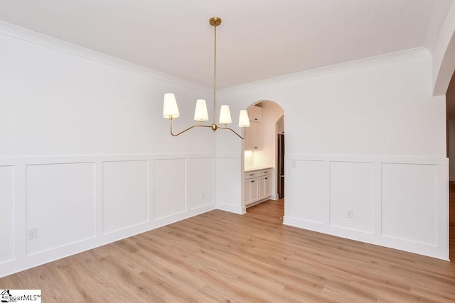 120 Club Cart Rd, Travelers Rest, SC 29690 - unfurnished dining area with a decorative wall, light wood-style flooring, arched walkways, a wainscoted wall, and crown molding