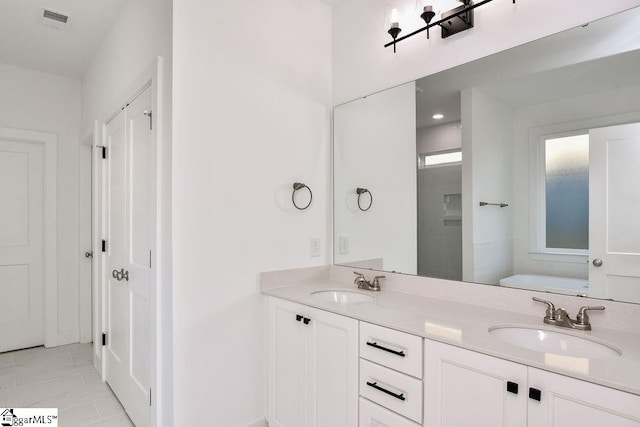 bathroom with tile patterned flooring, vanity, and a tub to relax in