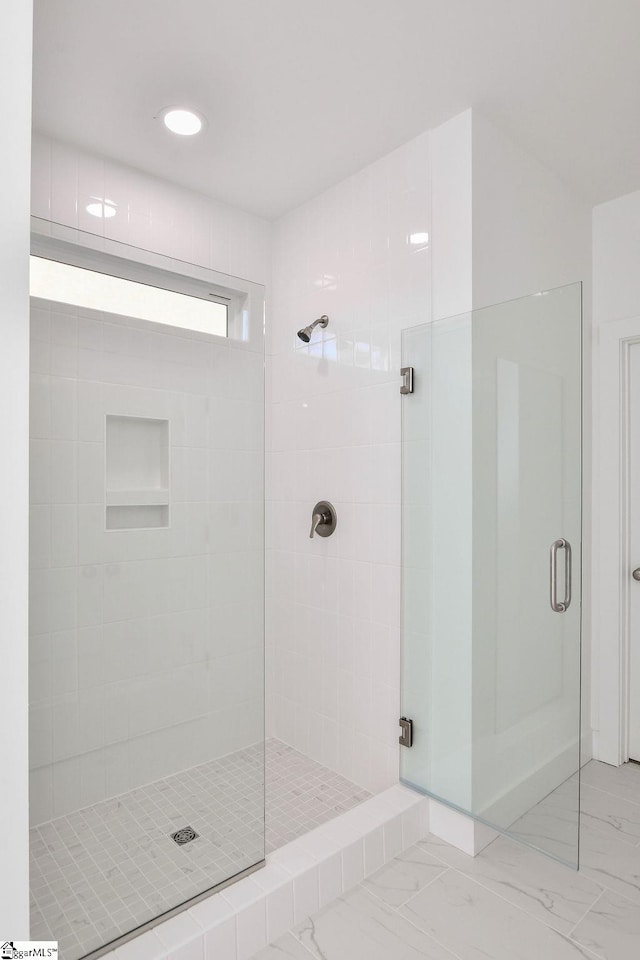 bathroom featuring a shower with shower door