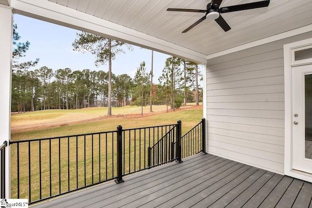 wooden deck with a yard and ceiling fan