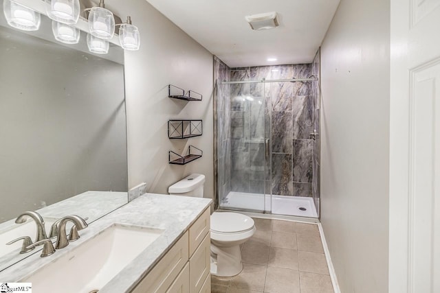 bathroom featuring tile patterned flooring, vanity, toilet, and a shower with door