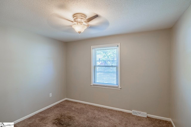 unfurnished room with ceiling fan, carpet floors, and a textured ceiling