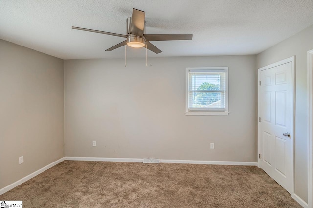 carpeted empty room with a textured ceiling and ceiling fan