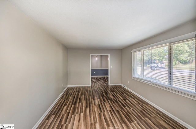 spare room with dark hardwood / wood-style flooring