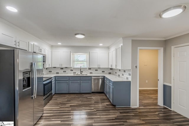 kitchen featuring sink, stainless steel appliances, backsplash, crown molding, and white cabinets