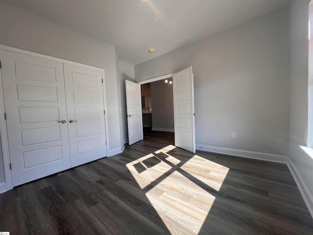 unfurnished bedroom with dark hardwood / wood-style flooring and a closet