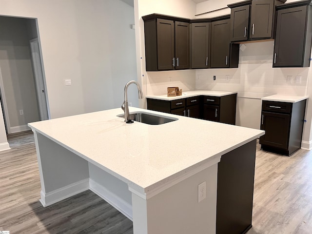 kitchen featuring backsplash, sink, and light wood-type flooring