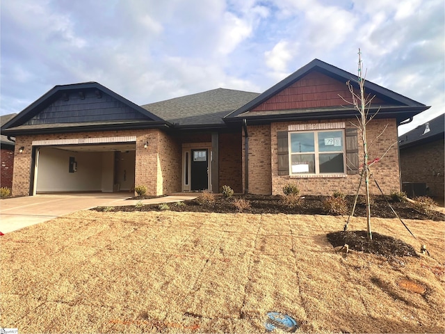 view of front of home featuring concrete driveway, brick siding, roof with shingles, and an attached garage