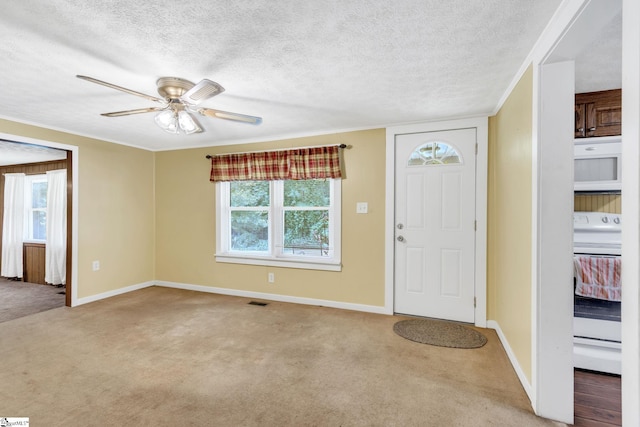 carpeted foyer featuring ceiling fan and a textured ceiling