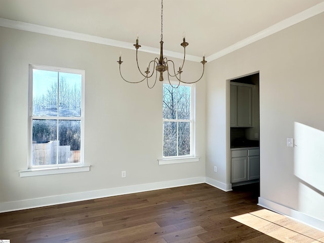 unfurnished dining area with dark wood-type flooring, crown molding, and a notable chandelier