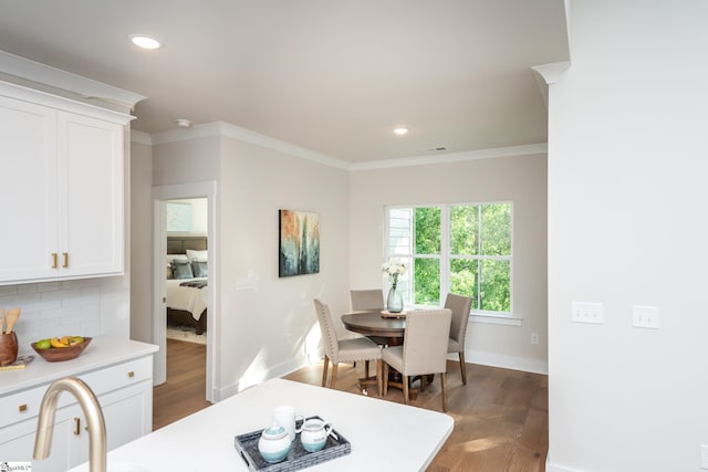 dining area featuring dark hardwood / wood-style floors and crown molding