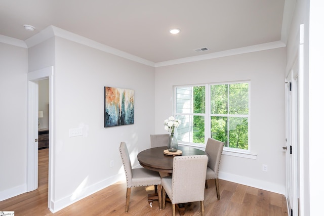 dining space featuring hardwood / wood-style floors and ornamental molding