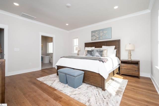 bedroom featuring hardwood / wood-style floors, ensuite bathroom, and ornamental molding