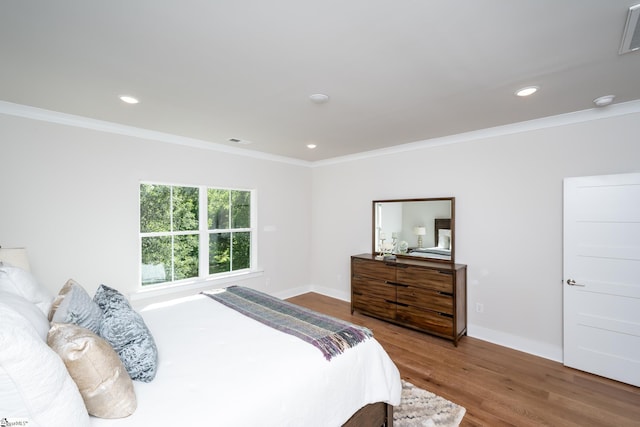 bedroom featuring hardwood / wood-style flooring and crown molding