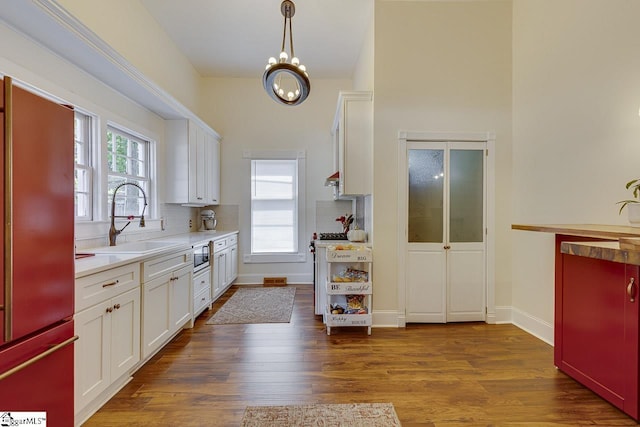 kitchen with pendant lighting, white cabinetry, backsplash, and high end refrigerator