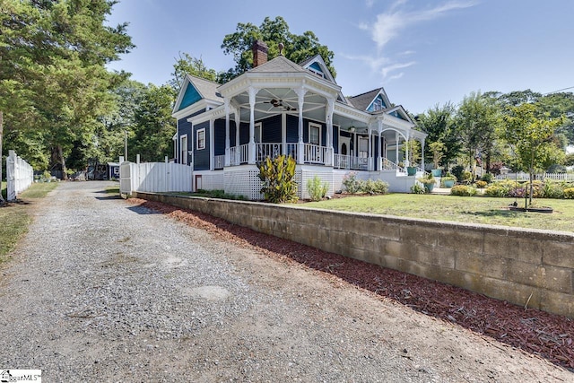 victorian home with ceiling fan, a porch, and a front yard