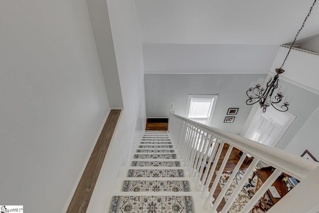 stairs featuring a chandelier