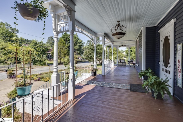 wooden terrace featuring covered porch and ceiling fan