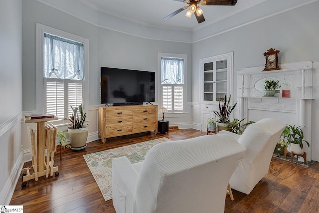 living room with dark hardwood / wood-style flooring, ceiling fan, and ornamental molding