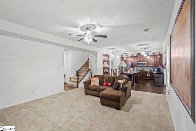 carpeted living room with ceiling fan