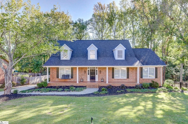 cape cod house featuring a porch and a front yard