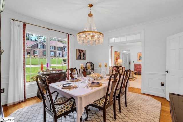 dining area with an inviting chandelier, a wealth of natural light, and crown molding