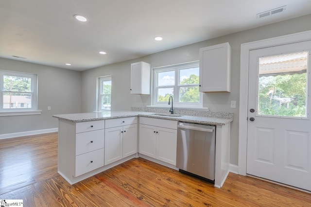 kitchen featuring white cabinets, sink, stainless steel dishwasher, light hardwood / wood-style floors, and kitchen peninsula