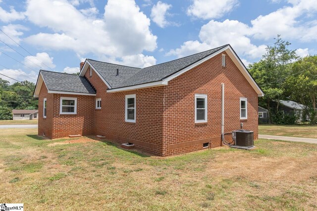 view of property exterior with central air condition unit and a yard