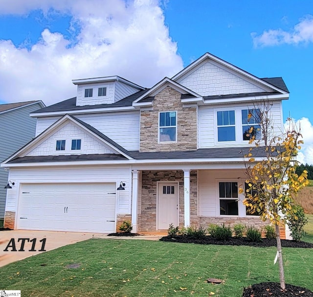 view of front facade featuring driveway, covered porch, a front lawn, stone siding, and a garage