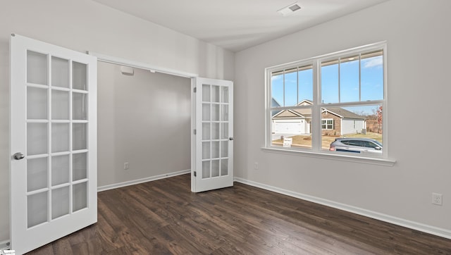 empty room with dark hardwood / wood-style floors and french doors